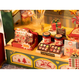 Schaufenster mit Zuckerstangen und Weihnachtskugeln am Miniaturhaus Weihnachten