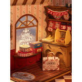 Lebkuchenhaus Bausatz von Rolife: Schaufenster mit Baumstammtorte und Plätzchen