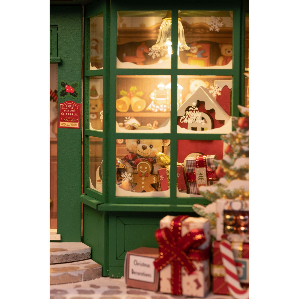 Santa's Toy Shop Bausatz mit grüner Fassade und roter Tür mit Kranz und Schleife