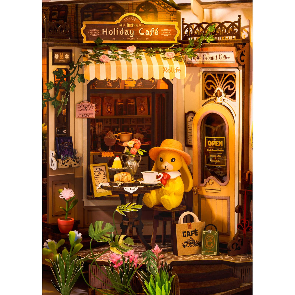 Orangefarbenes Kaninchen mit Schlappohren und rosa Hütchen im Rolife Miniaturcafé
